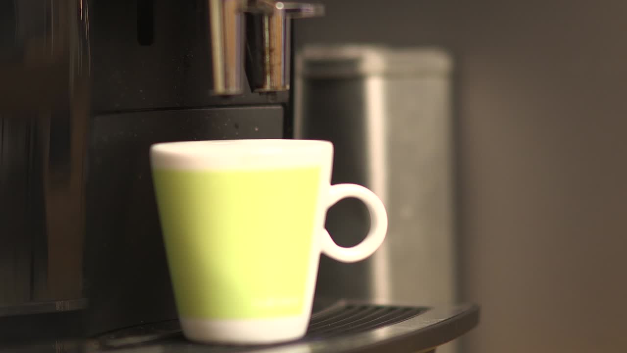 primer plano de una taza de café que está siendo hecha por una máquina