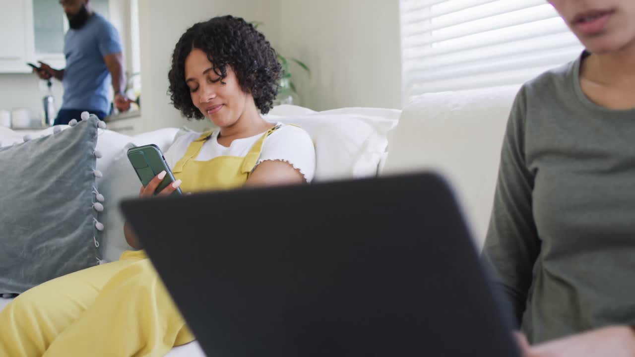 Diverse male and female friends using laptop and talking, working at home in slow motion