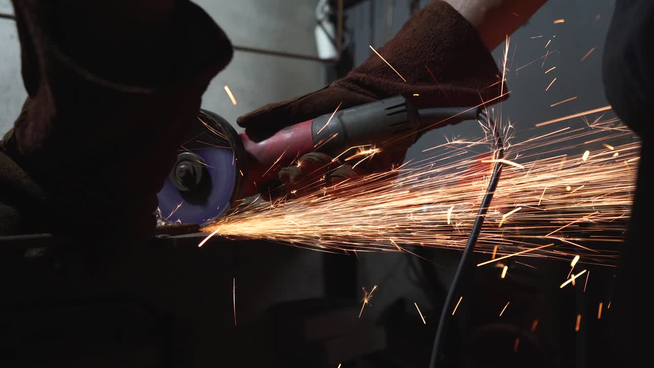 trabajador corta metal con una máquina de moler
