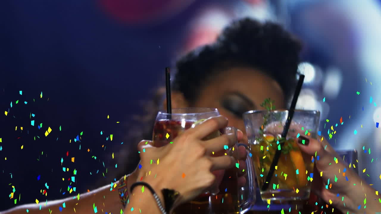 Confetti colorati che cadono su un gruppo di amici che brindano in un bar