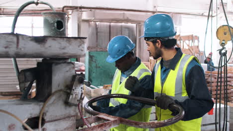 compañeros de trabajo con planos en la fábrica