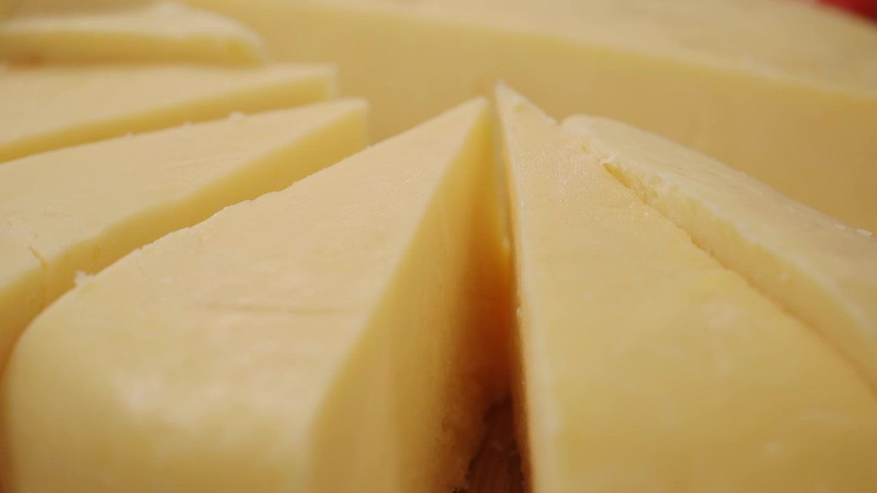 Primo piano di una forma di formaggio giallo a fette