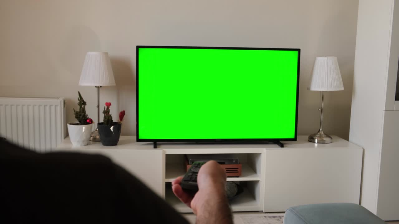 The person who changes channels in front of the green screen