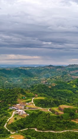 dark clouds glide by over a mountain landscape with forests and meadows