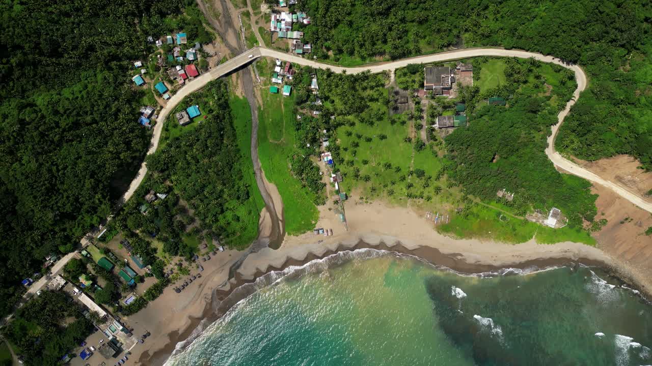 Top view forward aerial of the coastline near the Matawe Rock Formations in Dingalan, Aurora, gliding over turquoise waters, sandy beaches, and lush green hills along the shore