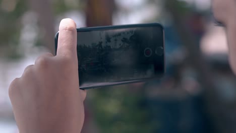 woman holds smartphone and shoots fishing boat closeup