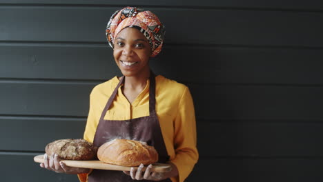 portrait of beautiful african american female baker with fresh bread