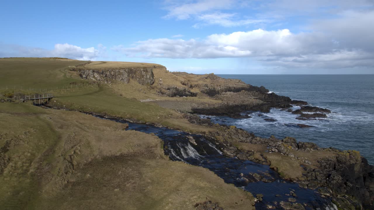 cascada y promontorio en el castillo de dunseverick, co antrim, irlanda del norte