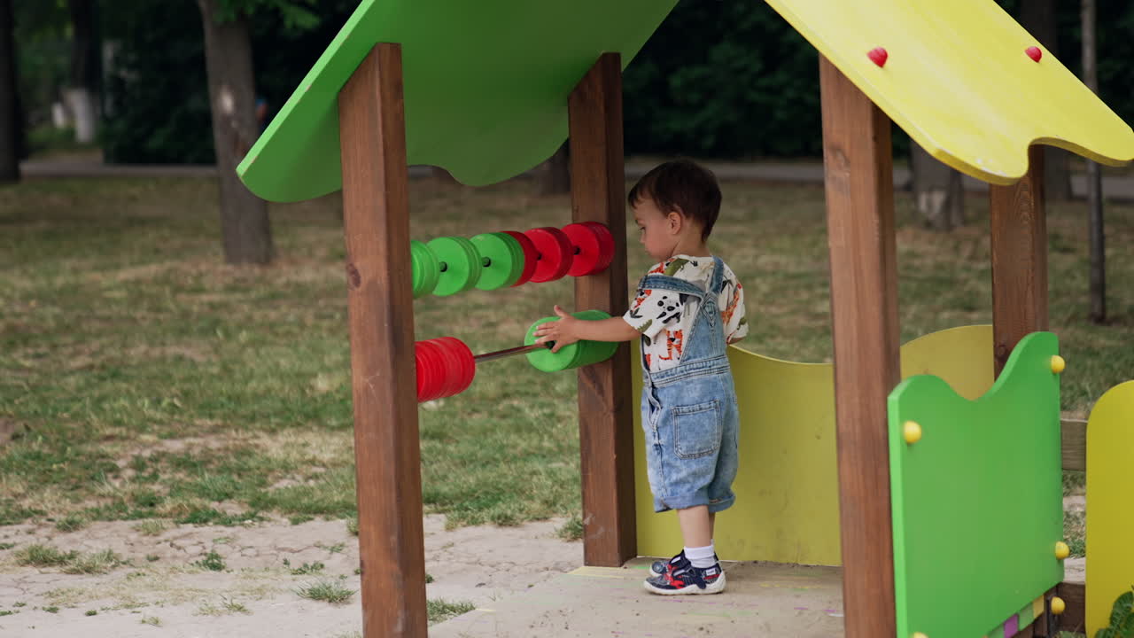 One year old toddler boy is on the playground. Little child learning to count through the game.