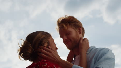 closeup married lovers hug outdoors. joyful couple touch cheek on summer sky