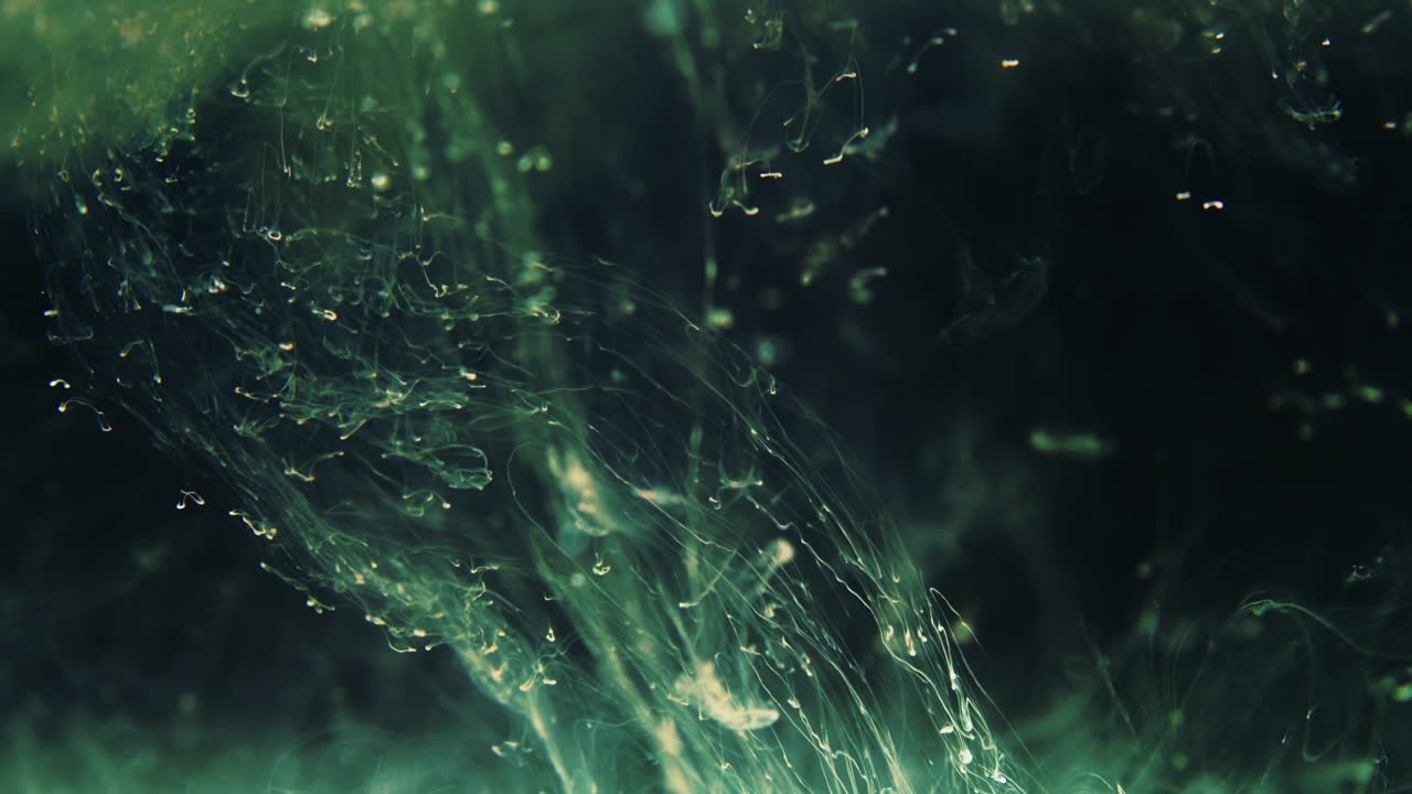 диффузия зеленых чернил в темной жидкости, абстракция