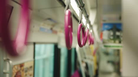 train interior on osaka monorail, close up shot of standing passenger straps