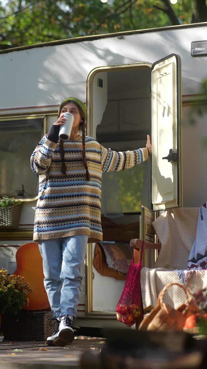 Donna che si gode un caffè all'aperto in campeggio in autunno