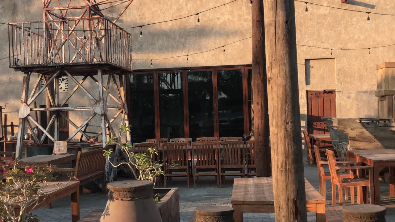 uae - 2020년 10월 10일: 나무 테이블과 의자가 있는 사막에 있는 중동의 버려진 오래된 마을