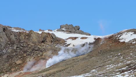 vapor que surge de la actividad geotérmica en una ladera de la montaña a principios de la primavera