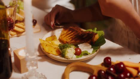 mujer comiendo comida a la parrilla con verduras y queso en una fiesta