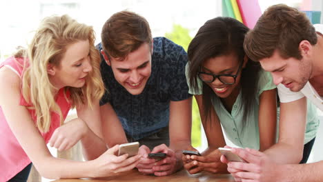 creative team using smartphones together
