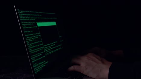 hands hacker using laptop computer hacking in the dark room
