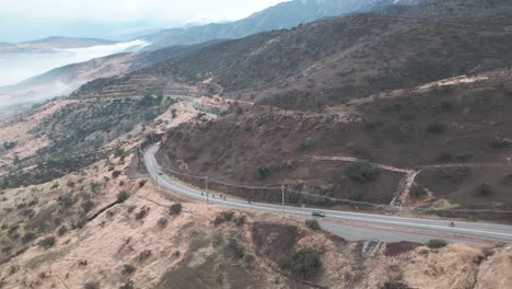 cyclists-racing-at-high-speed-along-the-top-of-a-hill-in-the-municipality-of-Barnechea,-Chile