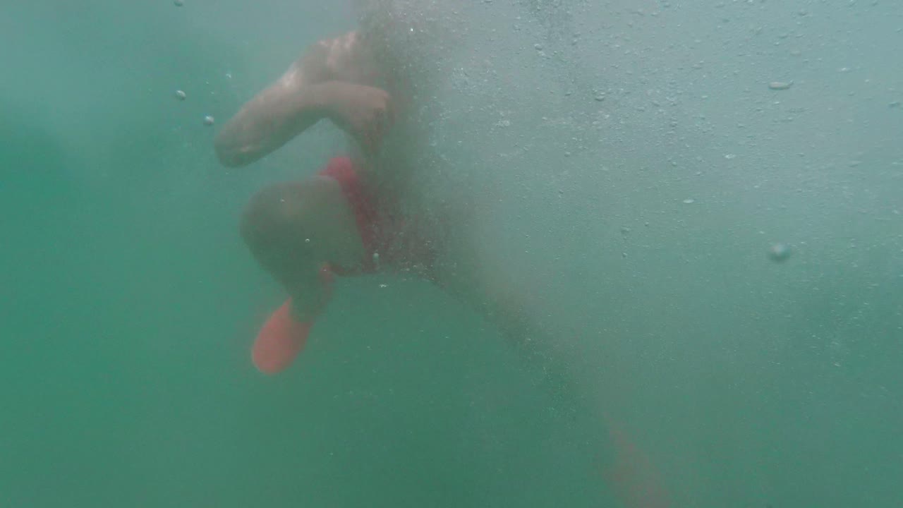 Young boy jumping from Pontoon edge into clear water, Slow motion