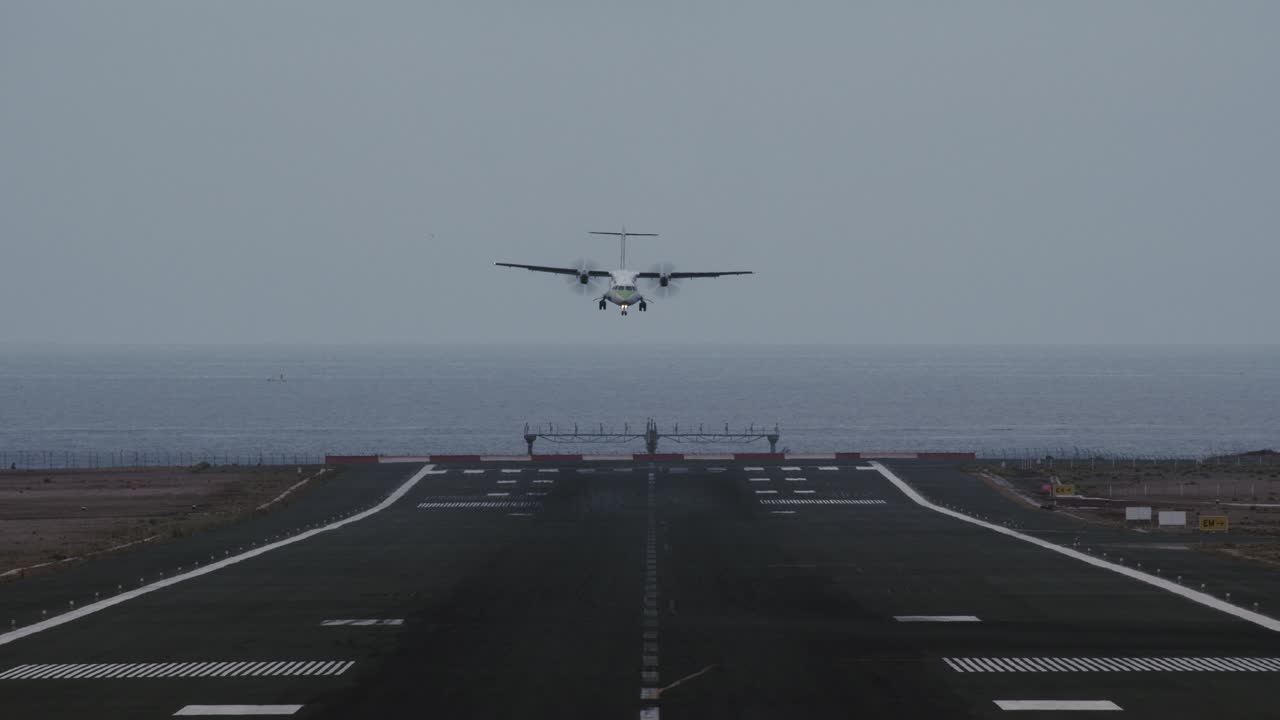 바다를 내려다보는 활주로에 착륙하기 위해 들어오는 비행기