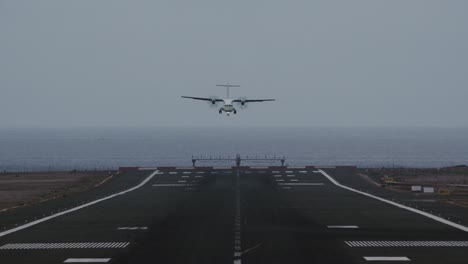 Airplane-coming-in-for-landing-on-runway-overlooking-ocean