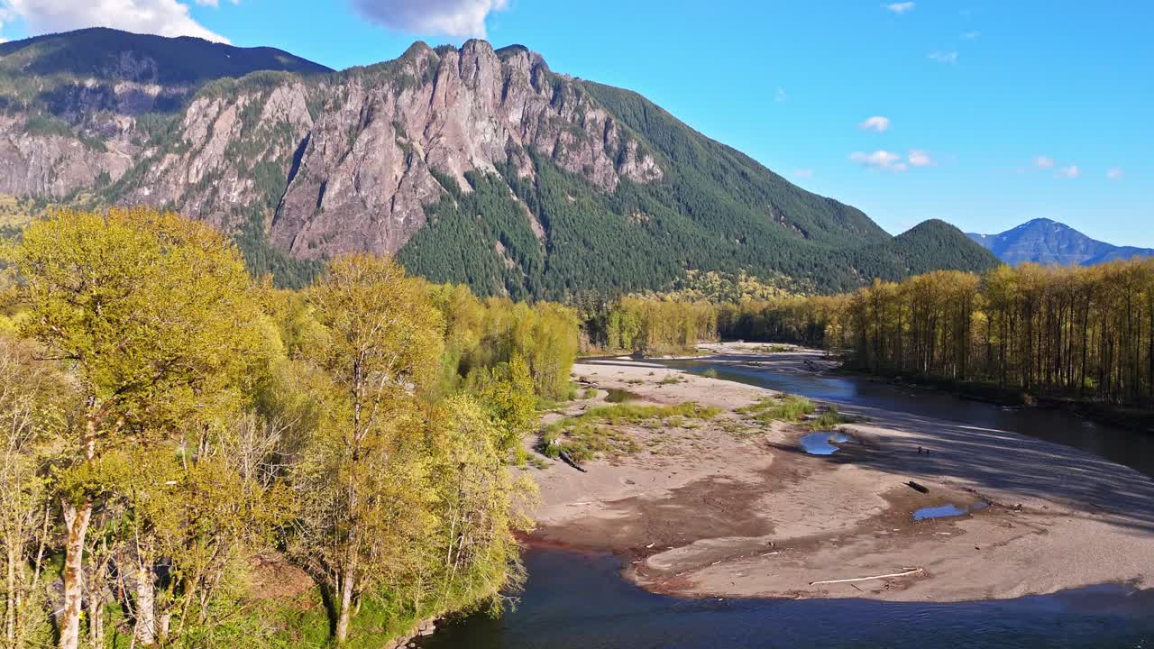 vista panorámica de drones volando sobre el río snoqualmie middle fork con el monte si en el fondo durante un día de cielo azul en north bend, estado de washington