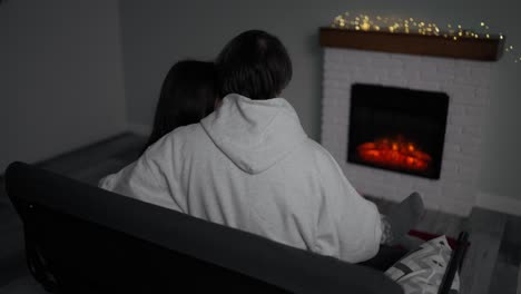 ⁇ 안은 벽난로  ⁇ 에 집에 앉아 있는 알아보기 힘든 커플
