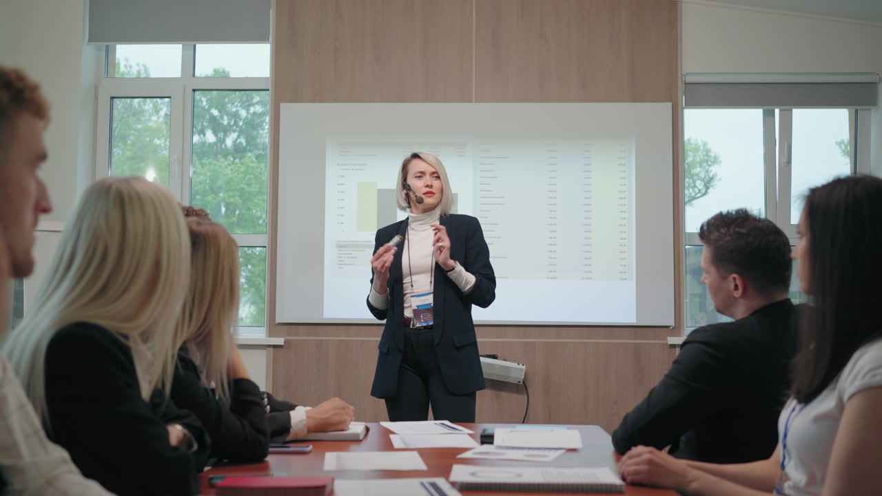 금융 분석 전문가가 비즈니스 컨퍼런스에서 연설을 하고 있습니다. 성인 여성이 보고서를 발표하고 있습니다.