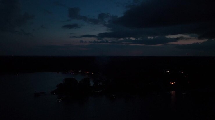 Ripresa aerea bassa in volo sopra un lago rurale di notte in Minnesota. 4K