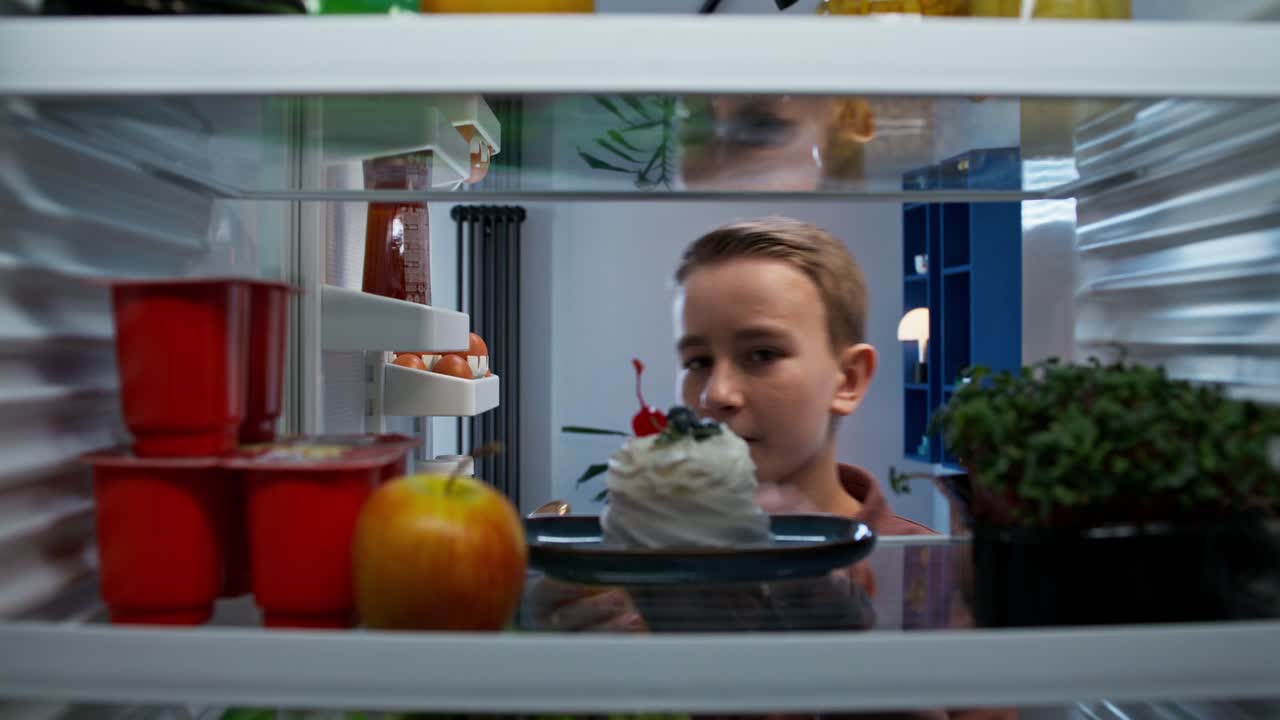 niño mirando dentro de un refrigerador