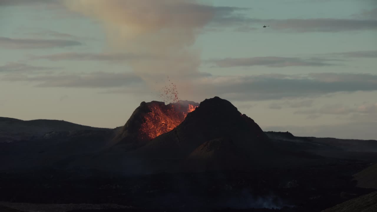 Elicottero che vola sopra un grande cratere vulcanico, Islanda di giorno
