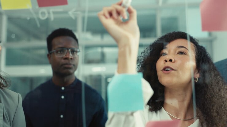 Black woman, writing and planning on glass