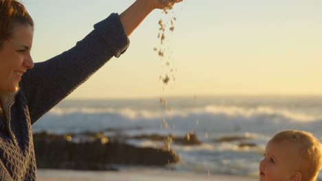 mother playing with her baby boy in the beach 4k