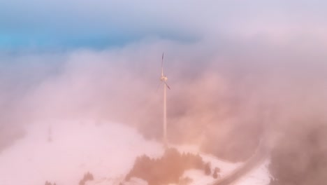 molino de viento en la hora dorada en las nubes - vista aérea cinematográfica