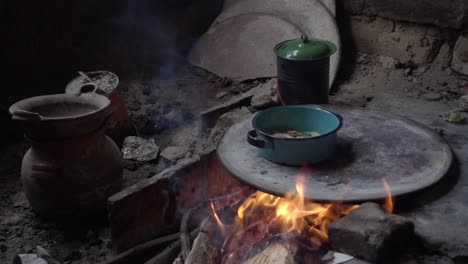 Slow-motion-shot-of-food-cooking-in-pots-on-a-wooden-fire-inside-a-home