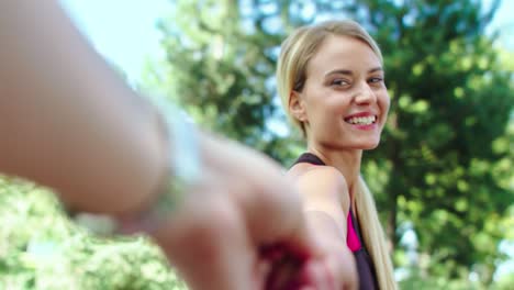 mujer sonriente coqueteando con un hombre en el parque. pareja feliz caminando en el parque de verano