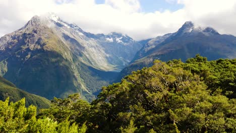 pan dramático de valles colgantes entre las montañas en nueva zelanda con arbustos ventosos