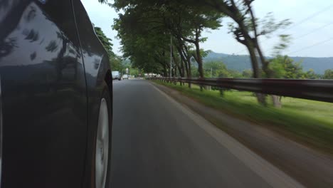 lado de un vehículo en movimiento que muestra tanto la carretera como las ruedas giratorias_1