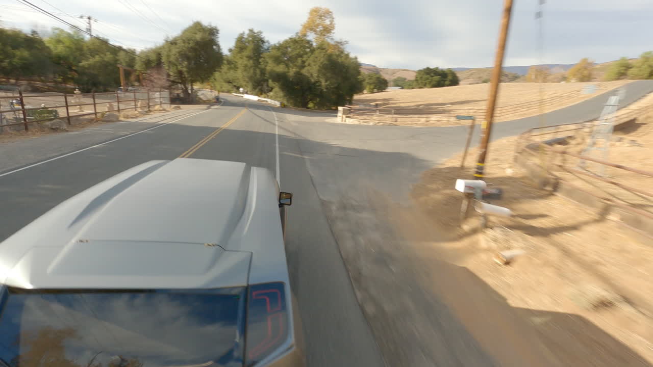 푸른 하늘 아래 시골 도로에서 운전하는 미래형 오프로드 자동차의 fpv 샷