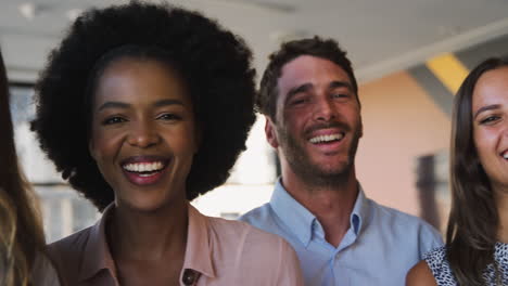portrait of smiling multi-cultural business team standing in modern office