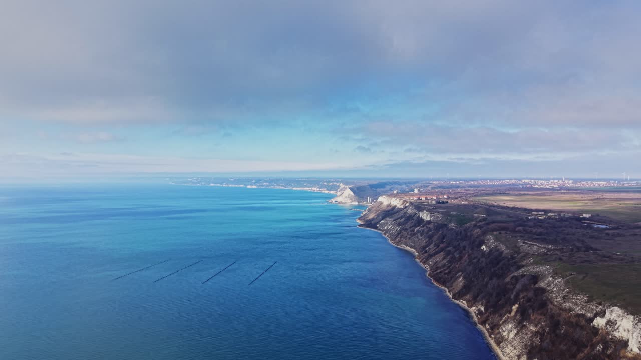 Vista della costa vicino a una città con scogliere e acqua in lontananza