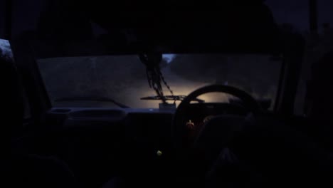 anonymous person driving car in dark nature