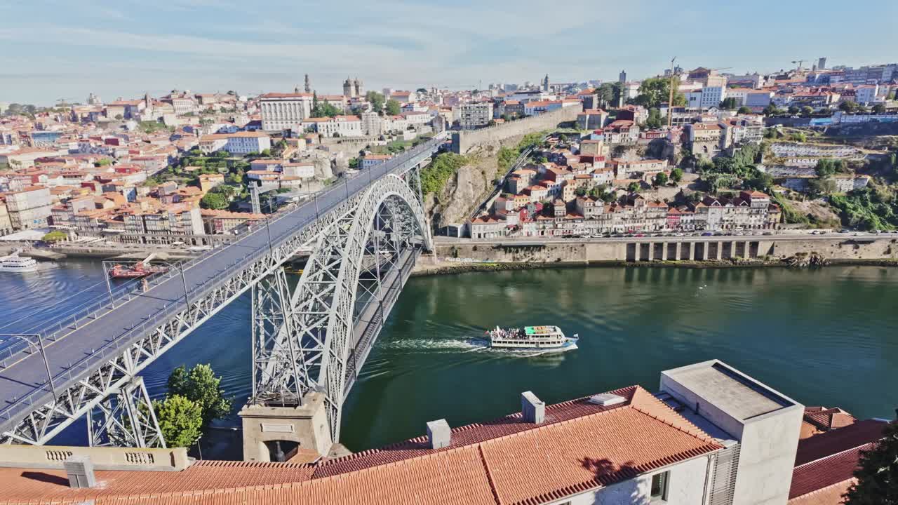 Scenic view of Porto and Vila Nova de Gaia with boat under Dom Luís I Bridge in bright daylight