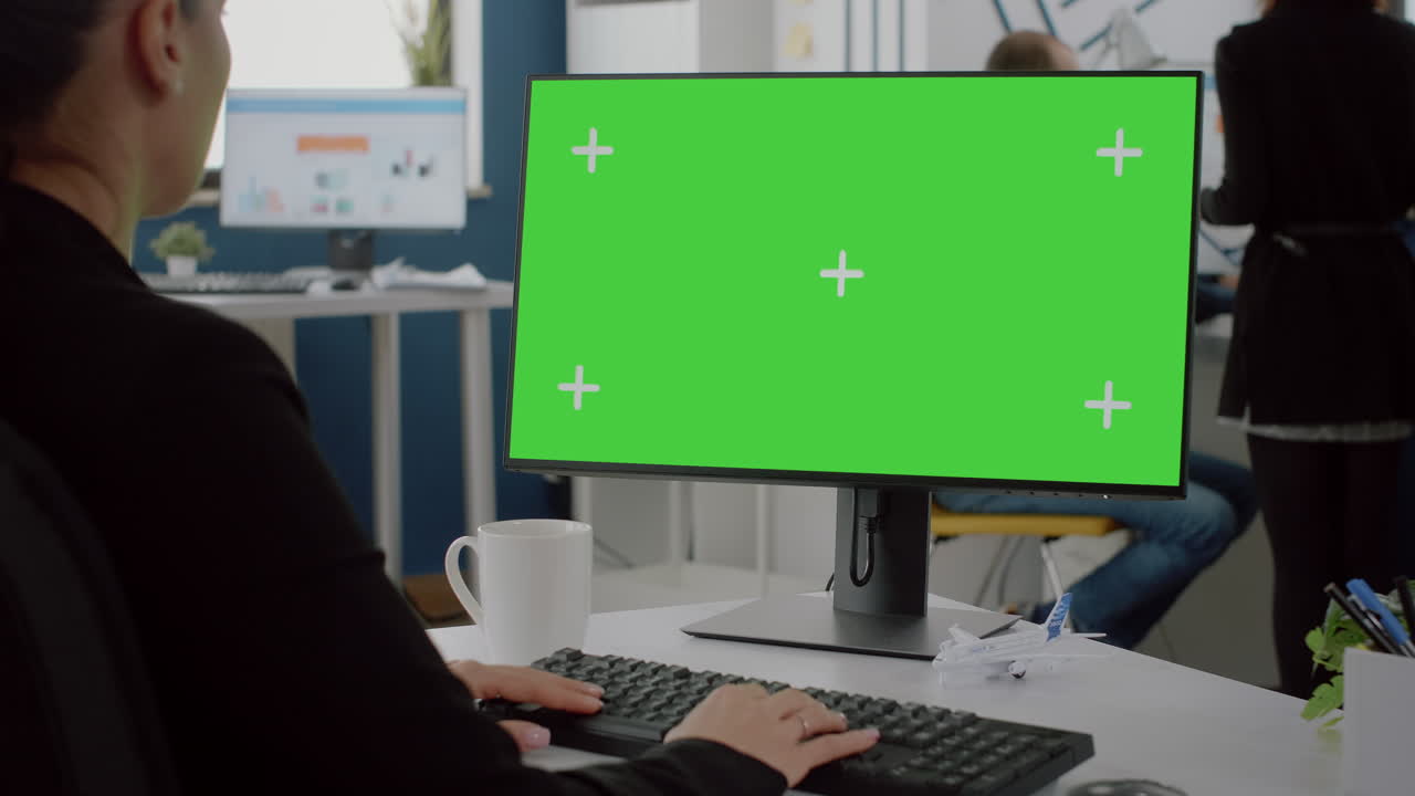 Close up of computer with horizontal green screen on desk