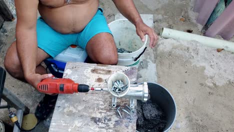 arriba hacia abajo inclinarse hacia arriba revelar hombre sin camisa trabajando molienda cebo para la pesca de chumming, cultura latina