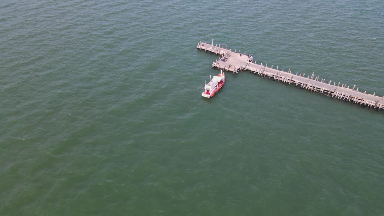 하강하는 공중 영상은 태국 파타야에서 보트와 일부 차량이 있는 파타야 낚시 부두를 보여줍니다.
