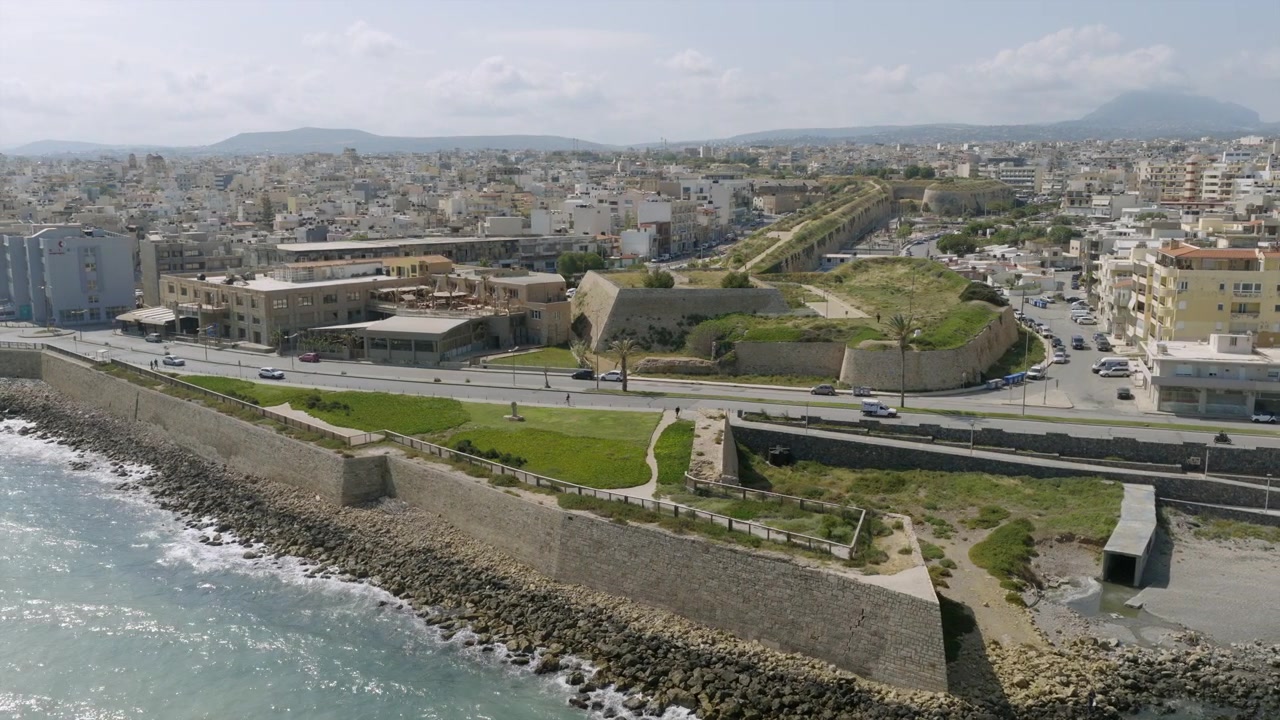 Veduta aerea di Heraklion, Creta, che mostra le storiche mura veneziane lungo la costa rocciosa, con gli edifici della città che si estendono verso le colline