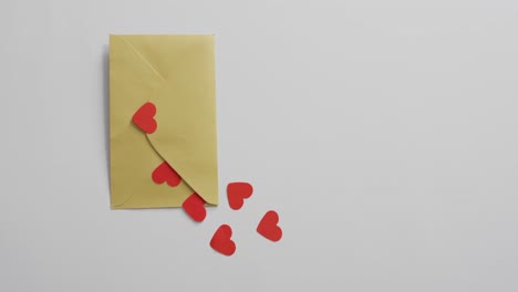 paper hearts and envelope on pink background at valentine's day