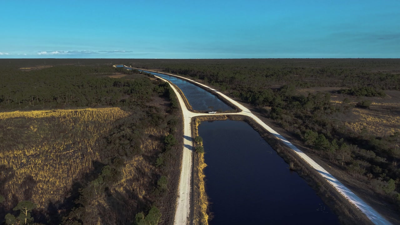 Drone reveal along a canal at the John C. and Mariana Jones Hungryland Wildlife Environmental Area that shows the vastness and diversity of the area including lakes, ponds, canals and prairies.